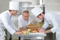 Chef training students in restaurant kitchen Royalty Free Stock Photo