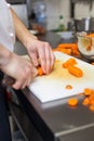 Chef in uniform preparing fresh carrot batons Royalty Free Stock Photo