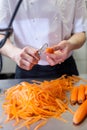 Chef in uniform preparing fresh carrot batons Royalty Free Stock Photo