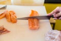 Chef use knife preparing a fresh salmon on a cutting board, Japanese chef in restaurant slicing raw salmon, ingredient for seafood Royalty Free Stock Photo