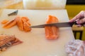 Chef use knife preparing a fresh salmon on a cutting board, Japanese chef in restaurant slicing raw salmon, ingredient for seafood Royalty Free Stock Photo