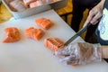 Chef use knife preparing a fresh salmon on a cutting board, Japanese chef in restaurant slicing raw salmon, ingredient for seafood Royalty Free Stock Photo