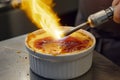 chef using a blowtorch to caramelize a crme brle Royalty Free Stock Photo