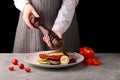 Chef using pepper mill. grilled vegetables and fish. pepper. female hands of the chef. on a black background Royalty Free Stock Photo