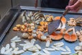 Chef using spatula frying seafood in buffet restaurant`s kitchen