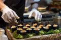 chef wearing gloves arranging uni sea urchin sushi