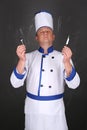 Chef wearing workwear, holding knife and fork Royalty Free Stock Photo