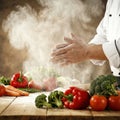 A chef clapping flour-covered hands over the vegetables, creating a dramatic Royalty Free Stock Photo