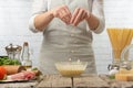 Chef in white uniform pours cheese in sauce into glass bowl for cooking pasta alla carbonara. Backstage of preparing traditional Royalty Free Stock Photo