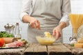 Chef in white uniform preparing sauce with cheese in glass bowl for cooking pasta alla carbonara. Backstage of preparing Royalty Free Stock Photo