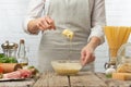 Chef in white uniform stir sauce with cheese in glass bowl for cooking pasta alla carbonara. Backstage of preparing traditional Royalty Free Stock Photo