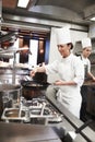 Chef, woman and frying pan with sauce in kitchen, catering service and prepare food for restaurant fine dining
