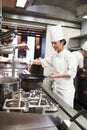 Chef, woman and frying pan with sauce in restaurant kitchen, catering service and prepare food for fine dining