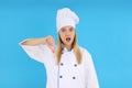 Chef woman showing thumb down on blue background Royalty Free Stock Photo