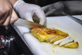 Chef cutting chicken fillet on board. Male chef hands cutting chicken meat on cutting board. Chef at work, kitchen Royalty Free Stock Photo