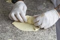 Chef wraps pizza ingredients in dough with his hands
