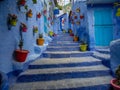 Chefchaouen the Blue city in Morocco with colourful pots decorating a blue stairwell