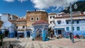 Chefchaouen medina center with unidentified people, blue city skyline on the hill, Morocco