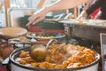 Cheff cooking delicious meat dish in a large pot.