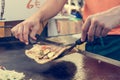 Cheff preparing traditional Mediterranean squid dish on a hot grill.