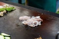 Cheff preparing traditional Mediterranean squid dish on a hot grill.