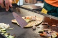 Cheff preparing traditional Mediterranean squid dish on a hot grill.