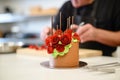 chefs hand piping rosettes on chocolate cake