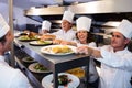 Chefs handing dinner plates through order station Royalty Free Stock Photo