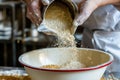 chefs hands pouring wheat flour into a mixing bowl Royalty Free Stock Photo