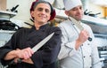 Chefs posing with knife in their restaurant kitchen Royalty Free Stock Photo