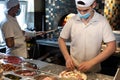 Chefs preparing pizza in a pizzeria wearing masks and protections during covid or coronavirus emergency