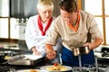 Chefs in a restaurant or hotel kitchen cooking Royalty Free Stock Photo