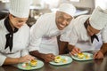 Chefs team finishing dessert plates Royalty Free Stock Photo