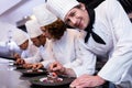 Chefs team finishing dessert plates Royalty Free Stock Photo