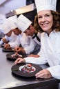 Chefs team finishing dessert plates Royalty Free Stock Photo