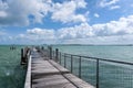 Chek Jawa Broadwalk old wooden floating jetty extends towards azure sea on Pulau Ubin Island, Singapore