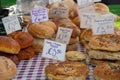 Large selection of Artisan home cooked bread on table with price tags for sale
