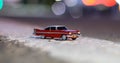 A red toy model of the car Christina Plymouth Fury on the asphalt at dusk with a blurry background Royalty Free Stock Photo