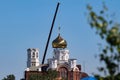 Chelyabinsk, Russia-08.06.2021: A crane that lifts the golden dome of the church during construction Royalty Free Stock Photo