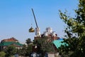 Chelyabinsk, Russia-08.06.2021: A crane that lifts the golden dome of the church during construction Royalty Free Stock Photo