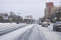 Snow-covered city street with vehicles. The road after a blizzard. Dangerous situation on the
