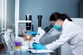 Chemical Advanced Research Laboratory, portrait of a female researcher using the microscope to look at culture cells on the Royalty Free Stock Photo