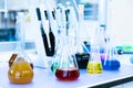 Chemical analysis, pharmacology and laboratory concept. Flasks with colored liquid reagents in a science laboratory. Blue toned