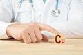 chemical element Cu necessary for human health. essential vitamins and element for humans. Cu alphabet on wood cube. doctor