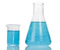 A chemical flask and beaker with blue liquids close-up isolated Royalty Free Stock Photo