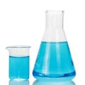 A chemical flask and beaker with blue liquids isolated on white Royalty Free Stock Photo