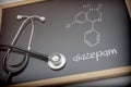 Chemical formula of diazepam written with chalk on a blackboard next to a stethoscope Royalty Free Stock Photo