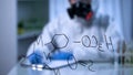 Chemical formula on glass board, scientist in gas mask writing on background