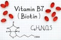 Chemical formula of Vitamin B7 Biotin with red pills.