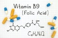 Chemical formula of Vitamin B9 Folic Acid with pills.